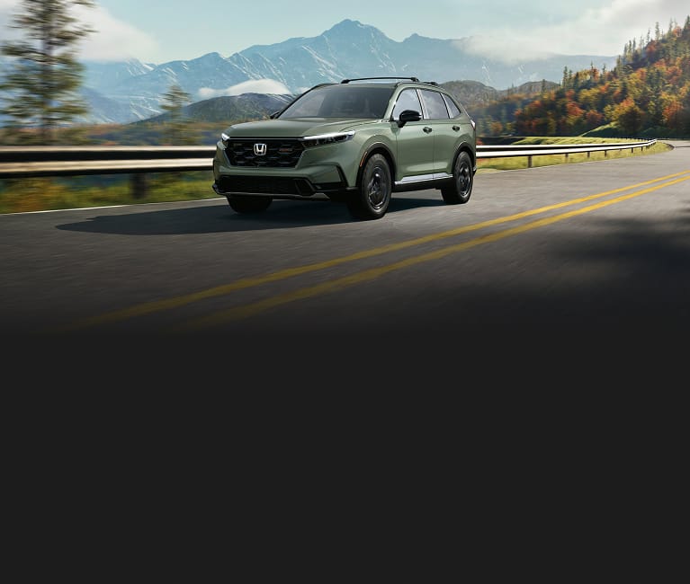 2027 Honda CR-V TrailSport Hybrid in Ash Green Metallic front driving on a winding mountain road (Compact Crossover SUV).
